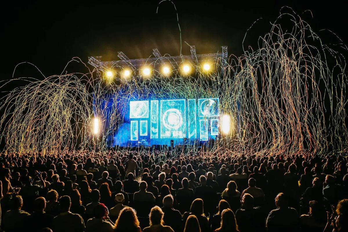 Crowd in front of a festival stage with fireworks