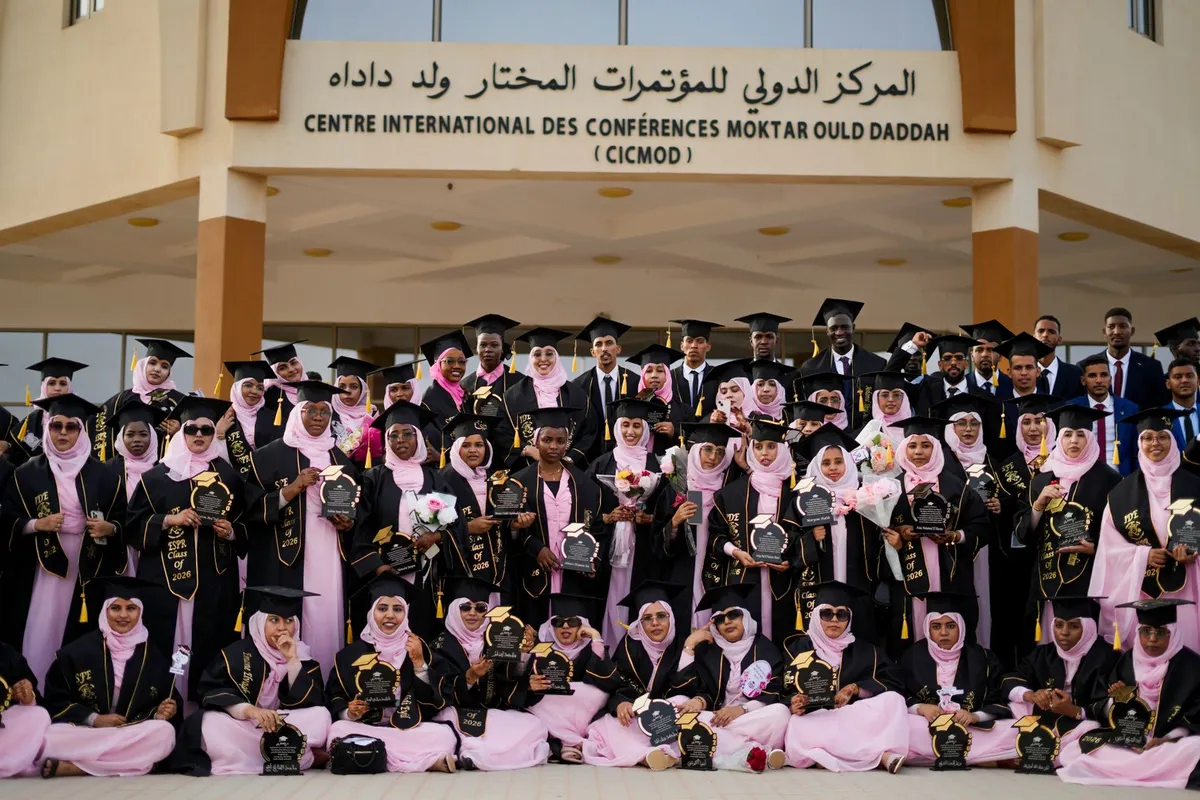 Graduates in caps and gowns posing together