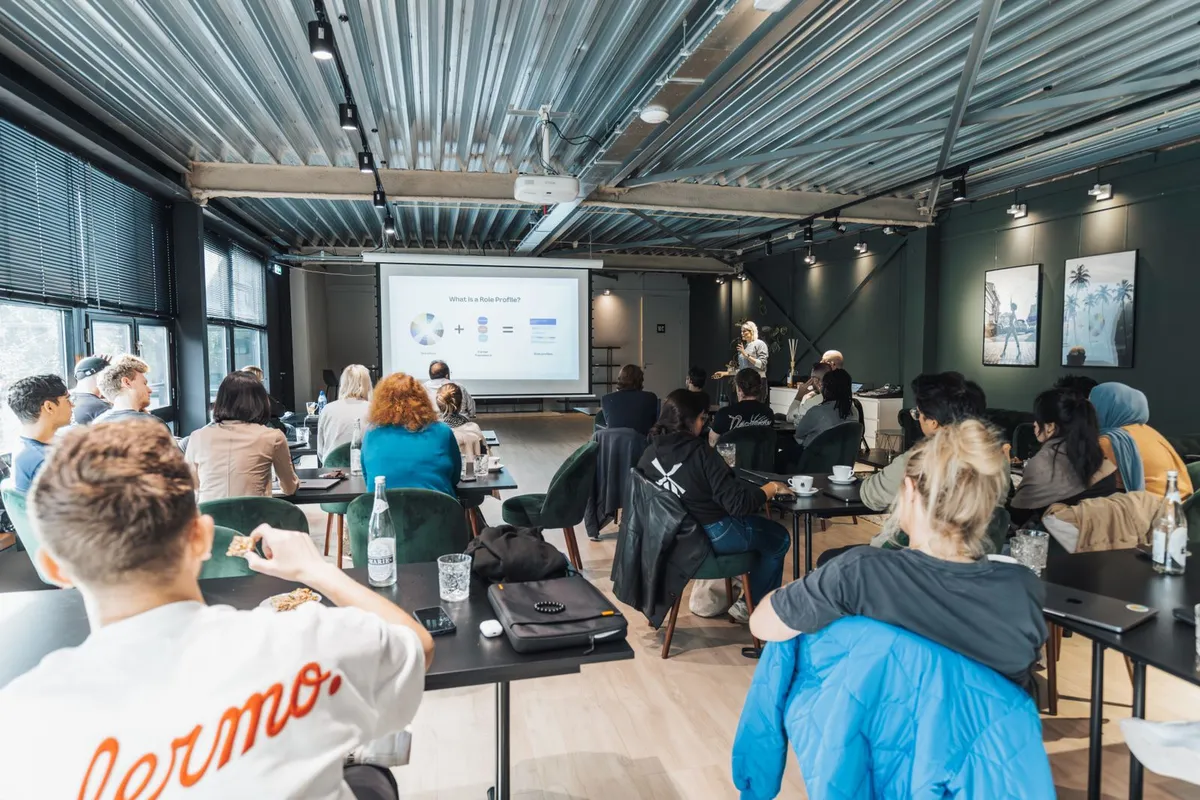 People at tables watching a presentation at a meetup